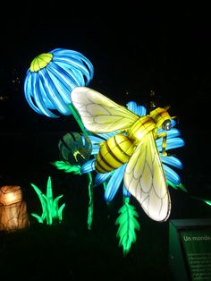 some lights that are in the grass with flowers on them and one light is yellow