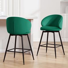 two green chairs sitting on top of a hard wood floor