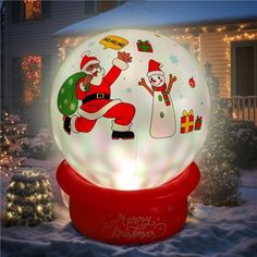 an inflatable christmas snow globe with santa and snowmen on it, surrounded by holiday lights