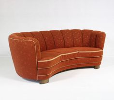 an orange couch sitting on top of a white floor