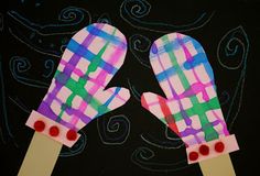 two paper mittens are shown on top of each other in front of a black background