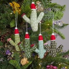 an ornament hanging from a christmas tree with cactus ornaments on it's branches