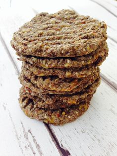 a stack of cookies sitting on top of a white wooden table next to a spoon