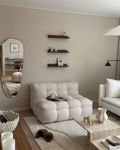 a living room filled with furniture and a large mirror on the wall above it's headboard