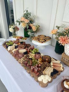 a table topped with lots of different types of food on top of a white table cloth