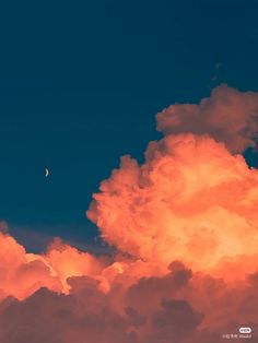 an orange cloud with a half moon in the sky