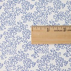 a ruler is on top of a blue and white wallpaper