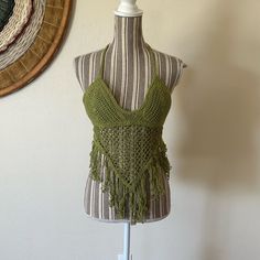 a mannequin wearing a green crochet top with fringes on it