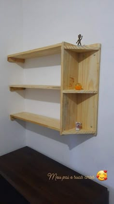 a wooden shelf with two shelves on the wall above it and a small figurine sitting on top