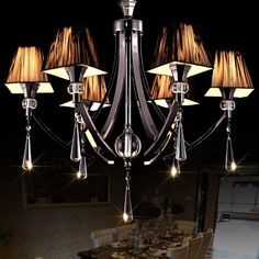 a chandelier with six lights hanging from it's sides in a dining room