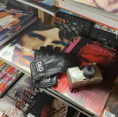 a pair of black gloves sitting on top of a table next to books and magazines