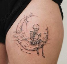 a woman's thigh with a skeleton sitting on the moon