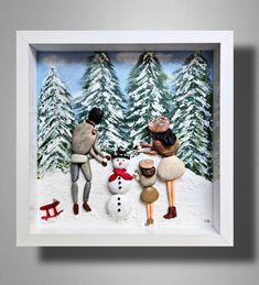 two people are making a snowman out of paper and some other things in front of them