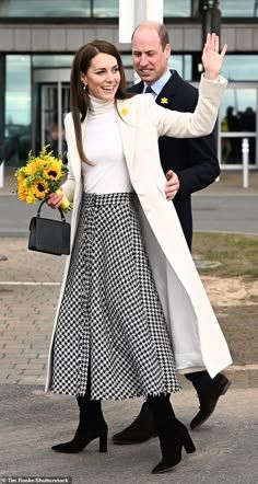 prince william and kate are waving to the crowd as they walk in front of an office building