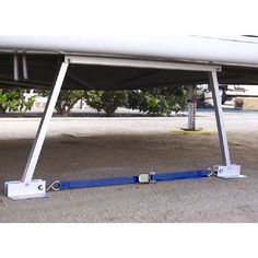 a white surfboard sitting on top of a sandy beach next to a metal pole