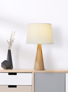 a table lamp sitting on top of a wooden dresser