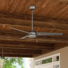 a ceiling fan mounted to the side of a wooden ceiling