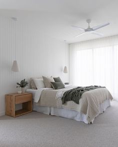 a bedroom with white walls and carpeted flooring has a bed in the middle