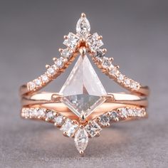 an engagement ring with a pear shaped diamond in the center and two smaller pear shaped diamonds on each side