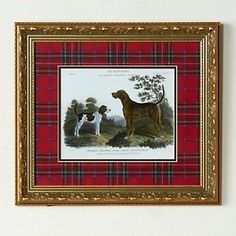 a framed print of two dogs on a red plaid background