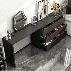 a black desk with drawers underneath it in a room next to a mirror and wine rack