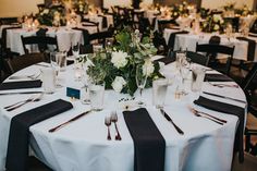 the table is set with black and white linens, silverware, and flowers