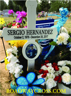 a memorial with flowers and a clock in the foreground reads sergio hernandez