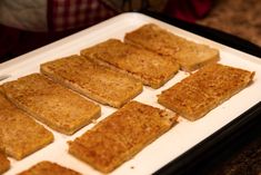 several pieces of bread sitting on top of a white tray in front of a person