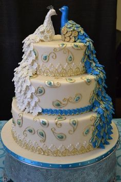 a three tiered wedding cake with blue and gold decorations