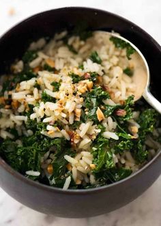 a bowl filled with rice, greens and nuts