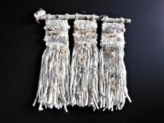 three white tassels hanging on a black wall