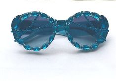 AUTHENTIC  (brand new in box) Classic, round sunglasses with a turquoise frame and azure gradient dark blue lenses. The temples are enriched with a Medusa encircled by crystals.   Luxury Rocks have customized and adorned them with blue Czech rhinestones crafted to make this one-of-a-kind beautiful design. Polycarbonate UV 400 Lenses UVA & UVB Protection Elegant Blue Sunglasses For Party, Elegant Blue Party Sunglasses, Party Sunglasses With Tinted Round Lenses, Round Tinted Sunglasses For Party, Round Tinted Lens Sunglasses For Parties, Round Tinted Sunglasses For Parties, Formal Blue Glass Sunglasses, Diy Glasses, Turquoise Frame