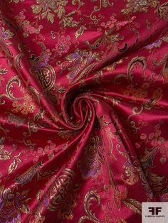 a red and gold paisley print fabric with large flowers on the bottom, in various colors