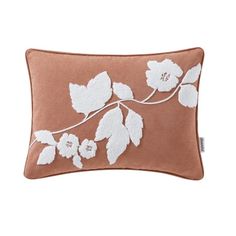 a brown and white pillow with flowers on it