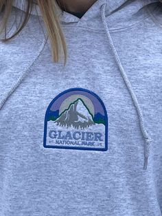 Glacier National park embroidered hoodie  Unisex sizing  Message me for sizes that are not listed!  Care Instructions:  Machine wash cold, hang to dry  Material on the back of the embroidery is designed to stabilize the shirt as it is being embroidered, it will soften over time with more washes. Visit my Etsy for more Nature-Inspired clothing : https://Stitchesbylindseyk.etsy.com Crew Neck Cotton Hoodie For Hiking, Heather Grey Cotton Sweatshirt For Outdoor, Heather Grey Cotton Hoodie For Outdoor, Outdoor Heather Grey Cotton Hoodie, Casual Hoodie With Embroidered Patch For Winter, Casual Winter Hoodie With Embroidered Patch, National Park Sweatshirt, National Park Gifts, Nature Shirts