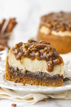 a piece of cheesecake on a white plate with some pecans in the background