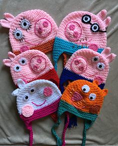 five crocheted pig hats with eyes and ears on top of each other, all in different colors