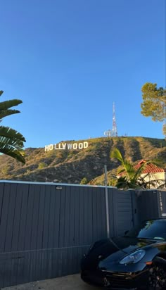 a car parked in front of the hollywood sign