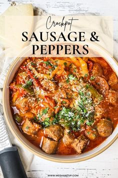 a white bowl filled with sausage and peppers on top of a table next to bread