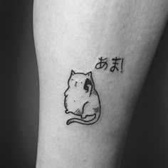 a black and white photo of a cat with chinese characters on it's leg