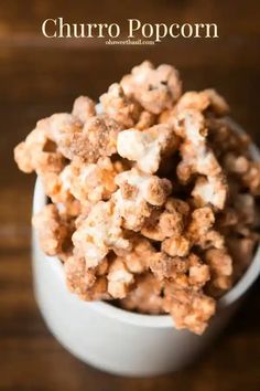 a white bowl filled with popcorn on top of a wooden table