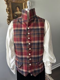 Jamie Fraser would love this plaid waistcoat vest, fashioned in 100% wool. The color palette is rich shades of cranberry, soft ivory, navy and chocolate. The back and linings are deep chocolate brushed cotton twill. Traditional 18th century pocket flaps , hand stitched buttonholes, topstitching, genuine horn buttons are the finishing touches.  Cotton tape ties make the vest adjustable from size 42 to 46 chest and waist. Please convo with any questions. Thank you for visiting Frocks & Foppery! Classic Red Vest For Fall, Classic Plaid Vest For Fall, Fall Vest With Buttons For Tailoring, Fitted Wool Vest For Fall, Classic Plaid Vest, Classic Plaid Sleeveless Vest, Classic Sleeveless Plaid Vest, 18th Century Waistcoat, 18th Century Pockets