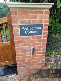 a sign on the side of a brick wall that says wellington cottage with a wooden door