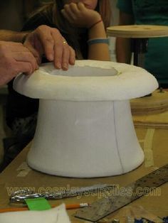 a woman is working on a white hat