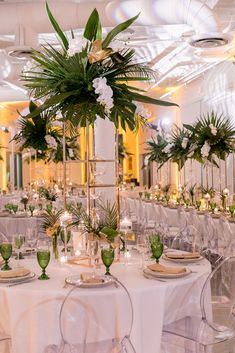 the tables are set up with white linens and green centerpieces