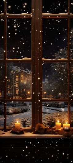 candles are lit in front of an open window on a snowy night