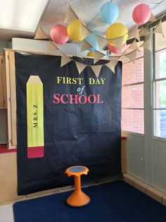 the first day of school sign is displayed in front of a bulletin board with crayons on it