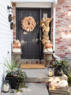 the front door is decorated with pumpkins and gourds