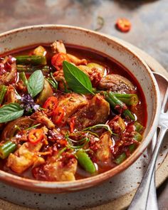 a bowl filled with meat and vegetables on top of a table