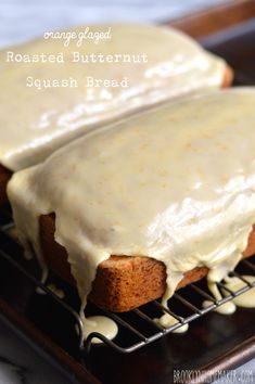 two slices of bread covered in frosting on top of a cooling rack with white icing